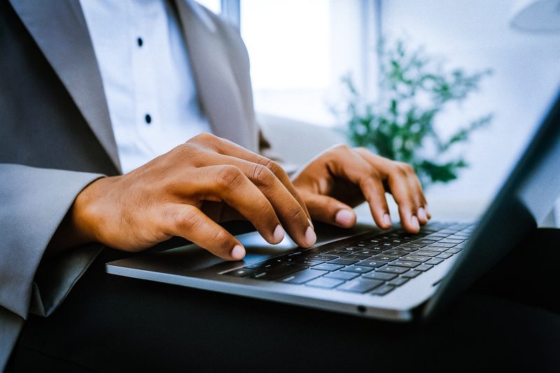 professioneel persoon typt op laptop tijdens werkdag